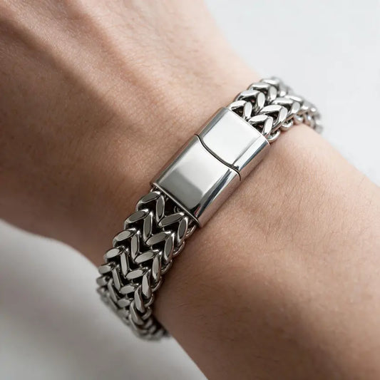 Ironclad silver Cuban chain bracelet with box clasp, worn on a man's wrist.