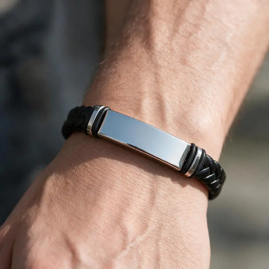 Sentinel braided leather bracelet with silver ID plate, worn on a man's wrist.