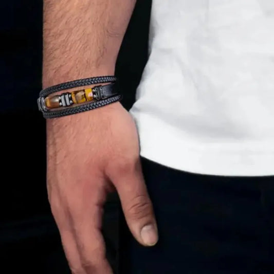 Close-up of a black leather tiger eye bracelet worn on a man's wrist