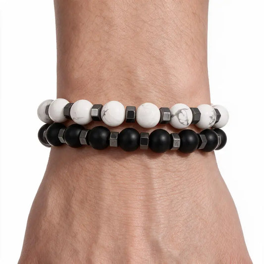 White howlite and matte black onyx bead bracelet set worn stacked on wrist, white background