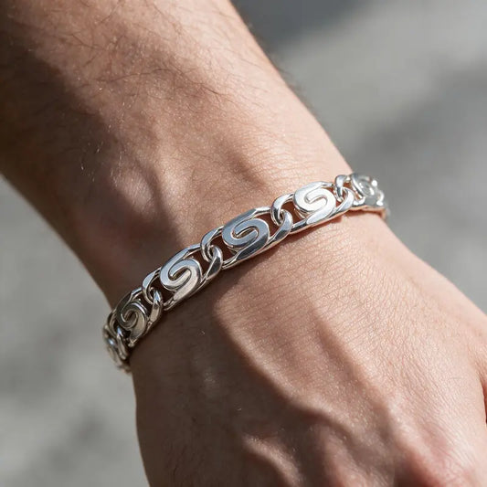 Silver byzantine scroll-link chain bracelet worn on the wrist