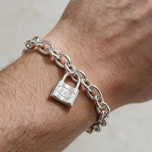 Silver oval cable-link chain bracelet with padlock charm worn on the wrist