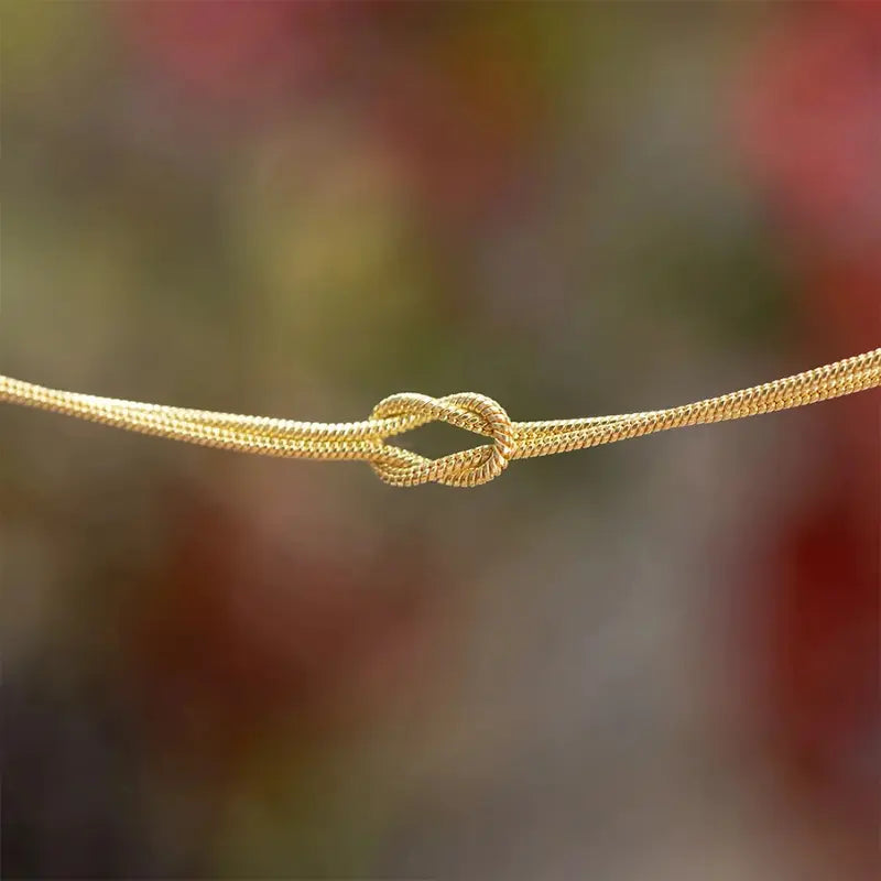 Close-up of gold snake chain knot detail