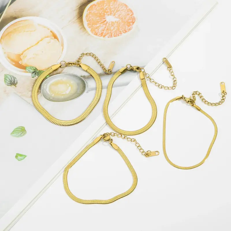Gold and silver snake chain bracelets on wrist lifestyle shot