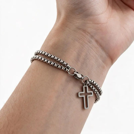 Stainless steel double chain cross bracelet worn on wrist, white background