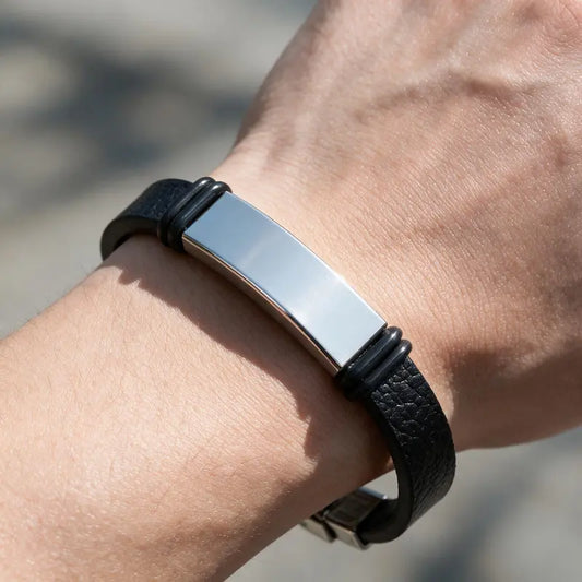 Anchor leather bracelet with silver ID plate, worn on a man's wrist.