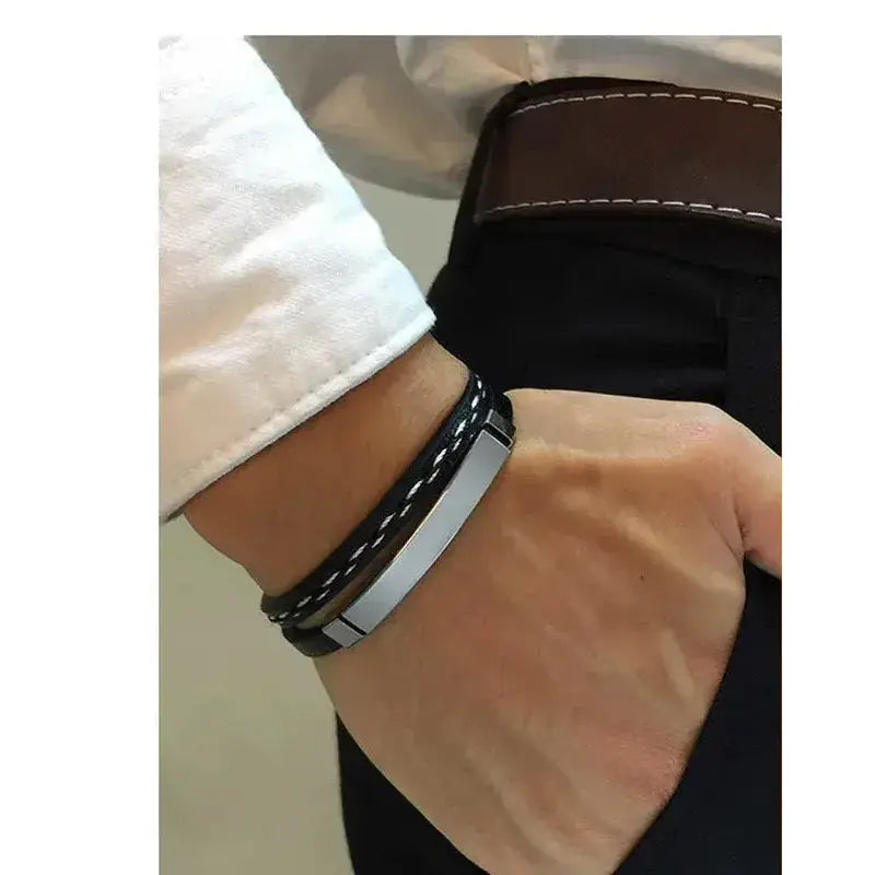 Crest leather bracelet with silver ID plate, worn on a man's wrist.