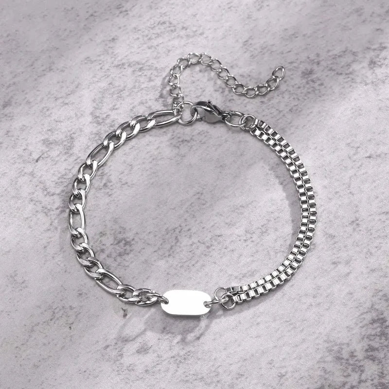 Insignia double-layer figaro and box chain bracelet with blank ID tag on a marble surface