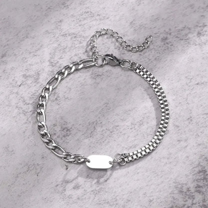 Insignia double-layer figaro and box chain bracelet with blank ID tag on a marble surface