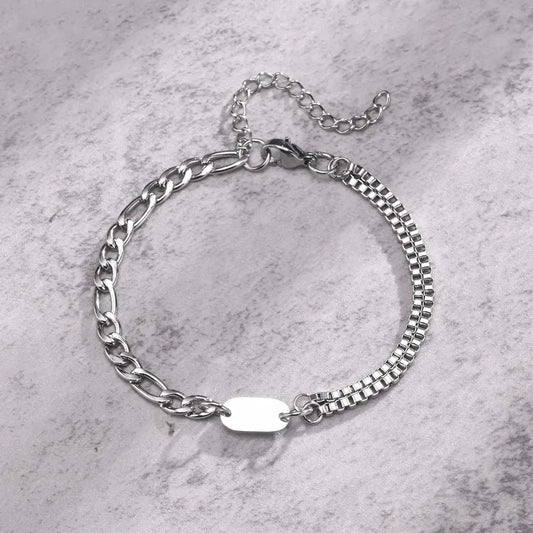 Insignia double-layer figaro and box chain bracelet with blank ID tag on a marble surface