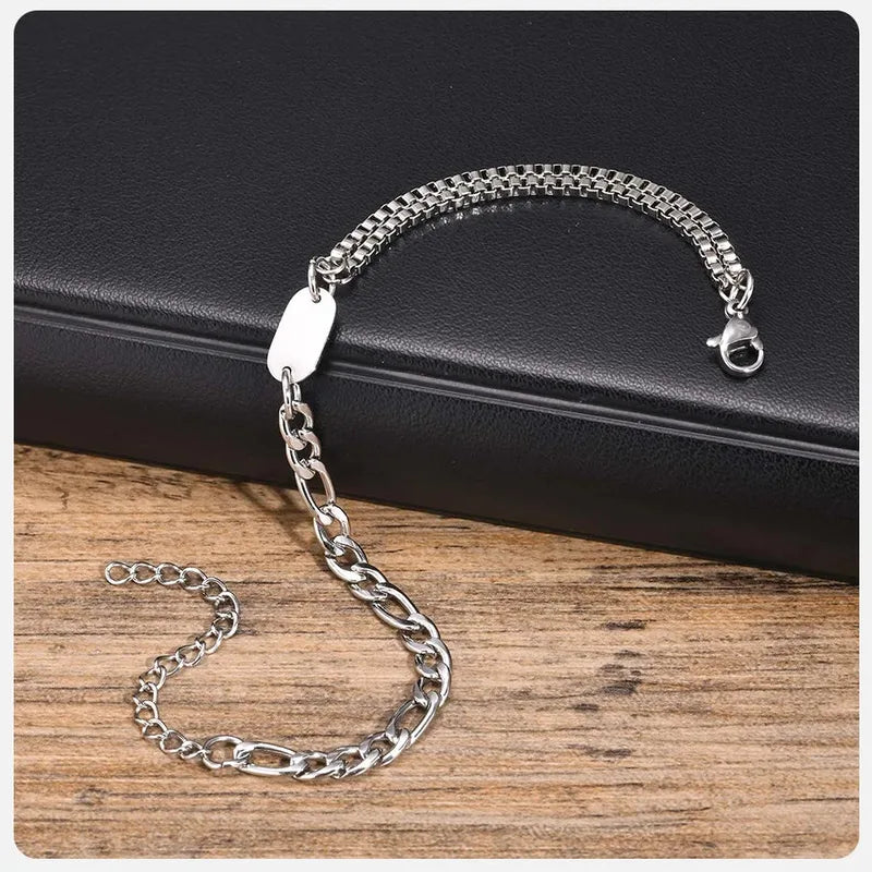Insignia chain bracelet laid out on a dark leather surface, clasp open