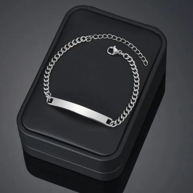 Blank silver nameplate bracelet displayed on a black gift box