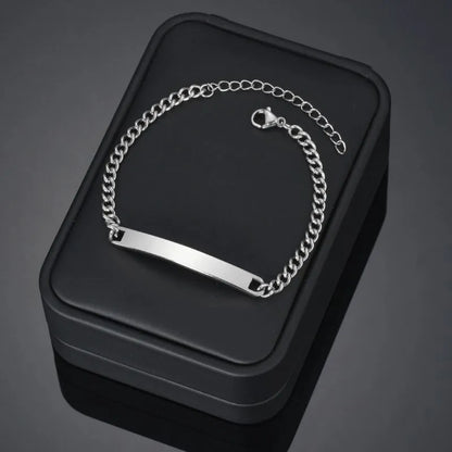 Blank silver nameplate bracelet displayed on a black gift box