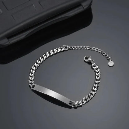 Blank silver nameplate bracelet resting beside a phone case