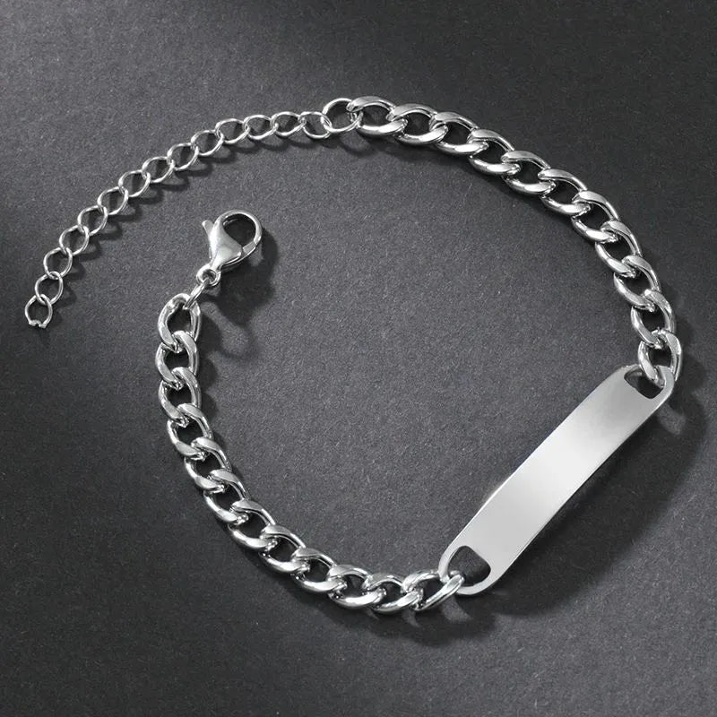 Blank silver nameplate bracelet on a dark textured background