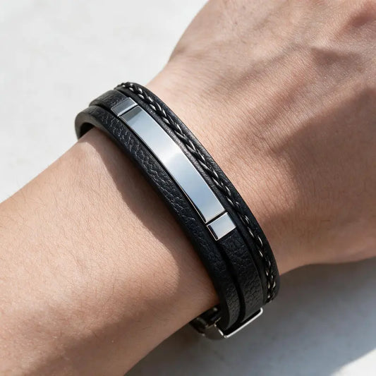 Tailor leather bracelet with silver ID plate, worn on a man's wrist.