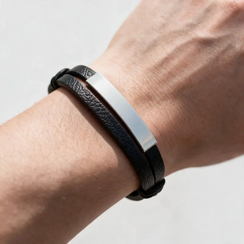 Weave leather bracelet with silver ID plate, worn on a man's wrist.