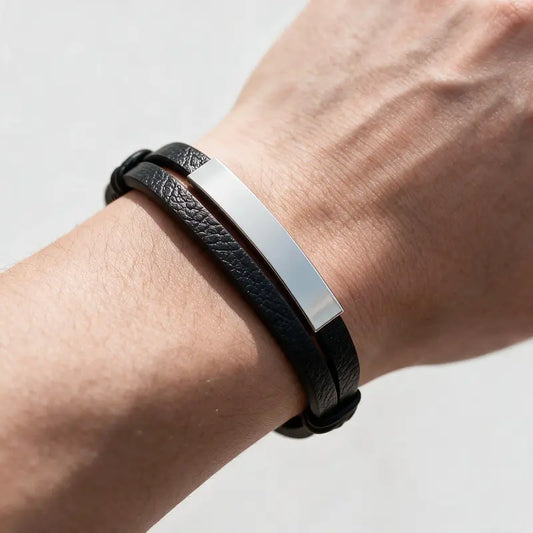 Weave leather bracelet with silver ID plate, worn on a man's wrist.