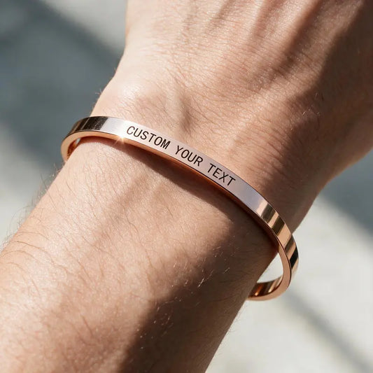 Whisper rose gold cuff bangle engraved with custom text, worn on a man's wrist.