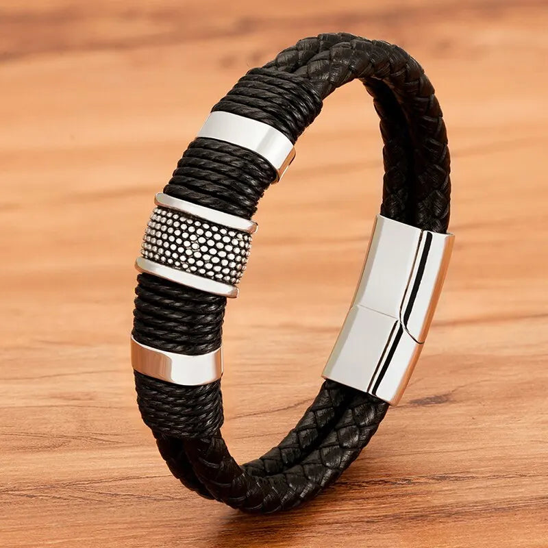 Silver woven leather rope bracelet with textured stainless steel rondelle beads, on a wood background