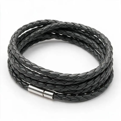 Charcoal grey braided leather bracelet coiled in a loop, on a white background.
