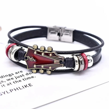Black leather bracelet with a red enamel guitar headstock charm, on a white background