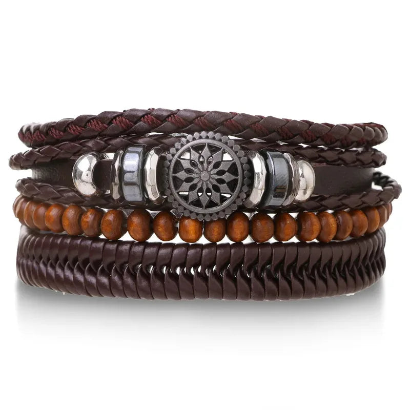Brown leather layered bracelet stack with a mandala charm, wood beads, and a herringbone band, on a white background.