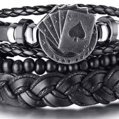 Black leather layered bracelet stack with a silver playing cards charm featuring a spade suit, on a white background