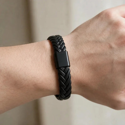 Black herringbone-woven leather bracelet with a matte black magnetic clasp, worn on a man's wrist.
