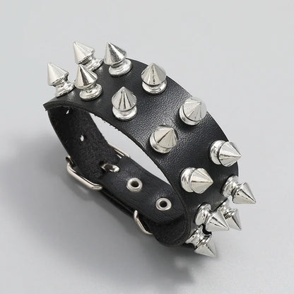 Angled view of a black leather cuff bracelet with three rows of silver spike studs