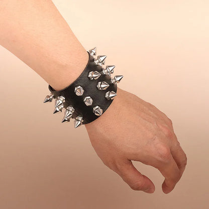 Black leather cuff bracelet with three rows of spike studs worn on the wrist