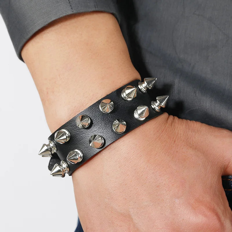 Black leather cuff bracelet with two rows of spike studs worn on the wrist