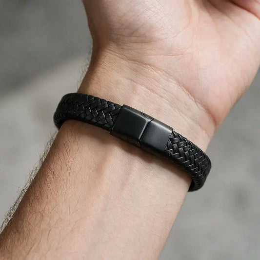 Black braided leather bracelet with a matte black magnetic clasp, worn on a man's wrist.