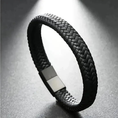 Black braided leather bracelet under dramatic side lighting, showing the rectangular magnetic clasp.