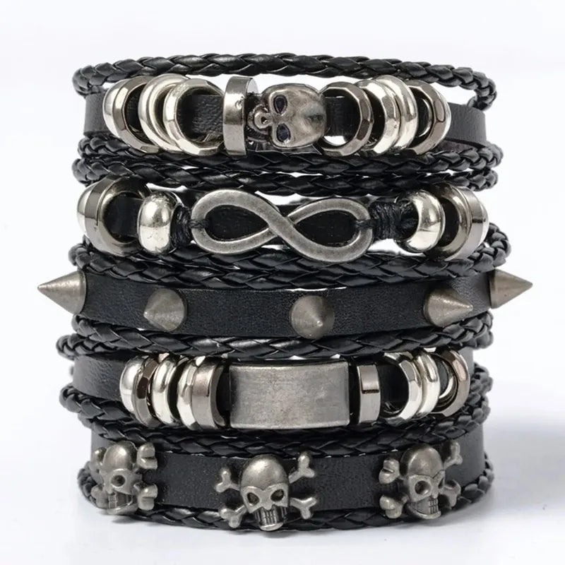 Five-piece black leather bracelet stack with a skull bead, infinity charm, and studded rivet band, on a white background.
