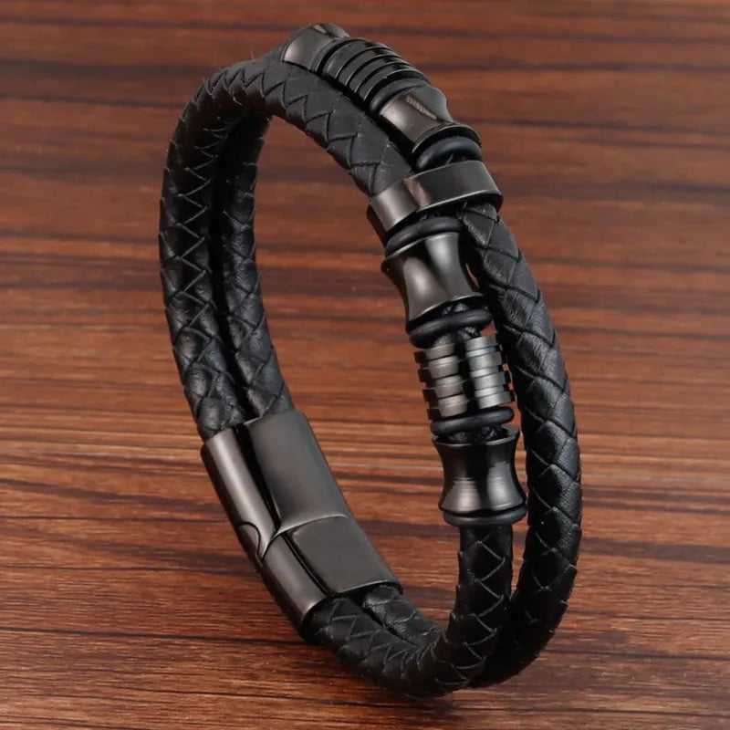 Multi-strand leather bracelet with a cluster of gunmetal grey metal rings, on a white background