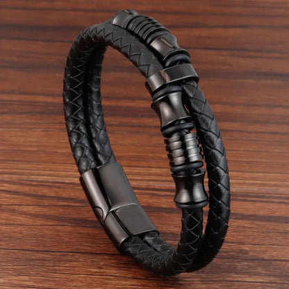 Multi-strand leather bracelet with a cluster of gunmetal grey metal rings, on a white background