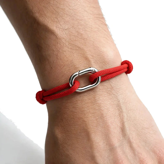 Red nylon cord bracelet with an oval alloy spring-clip clasp, worn on wrist