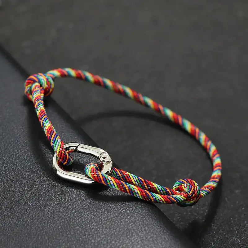 Close-up of the spring-clip clasp on a rainbow-colored cord bracelet