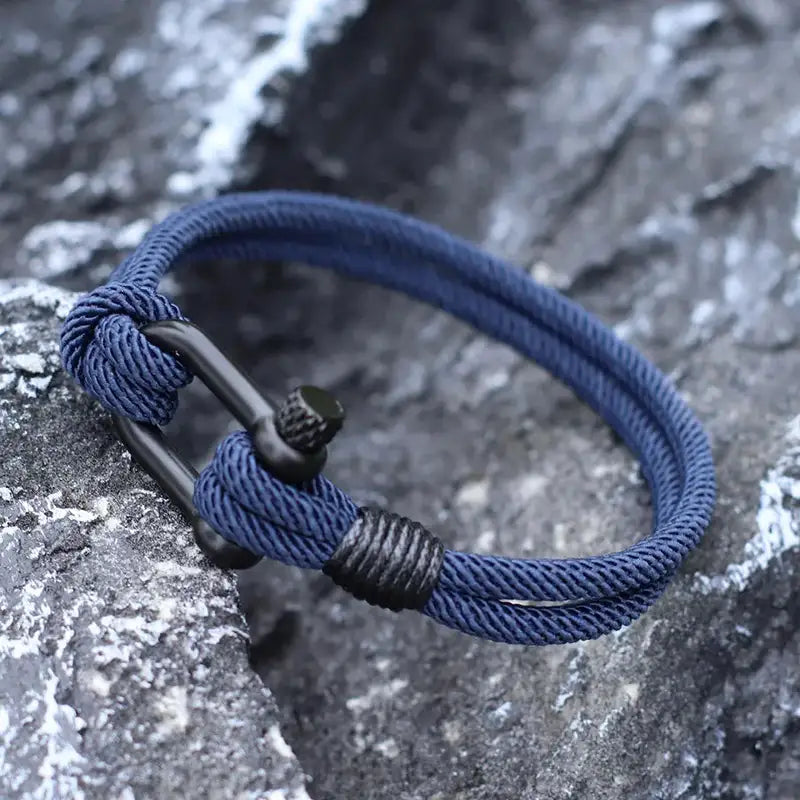 Navy rope bracelet with shackle clasp worn outdoors on rocks