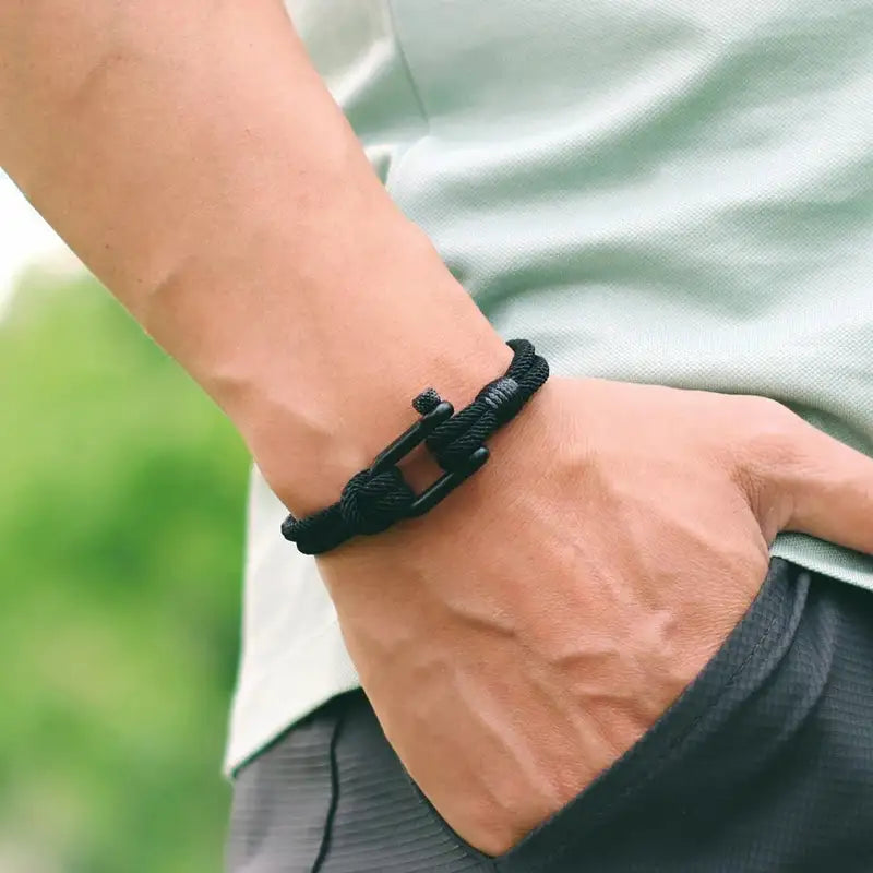 Black double-strand rope bracelet with shackle clasp worn on the wrist