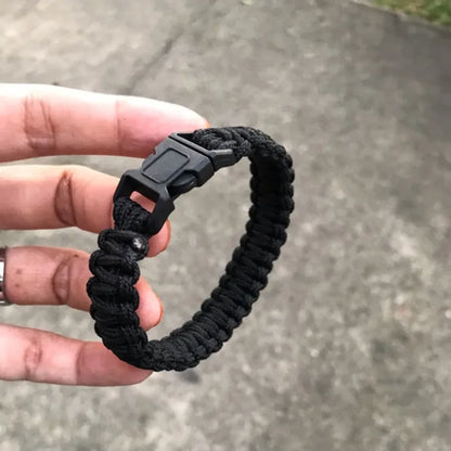 Black cobra-weave paracord bracelet worn on the wrist
