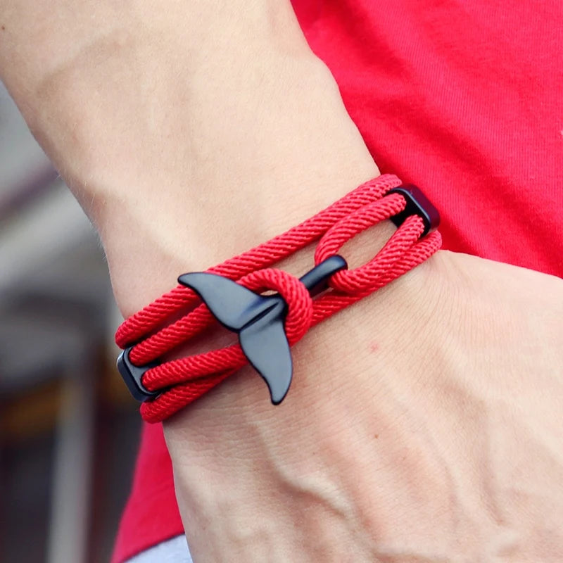 Manta ray charm in black finish on a red rope bracelet, worn on the wrist