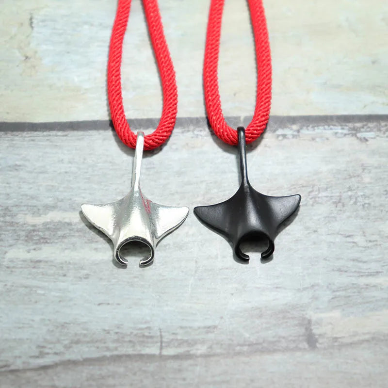 Manta ray charms in silver and black finish shown side by side on red cord