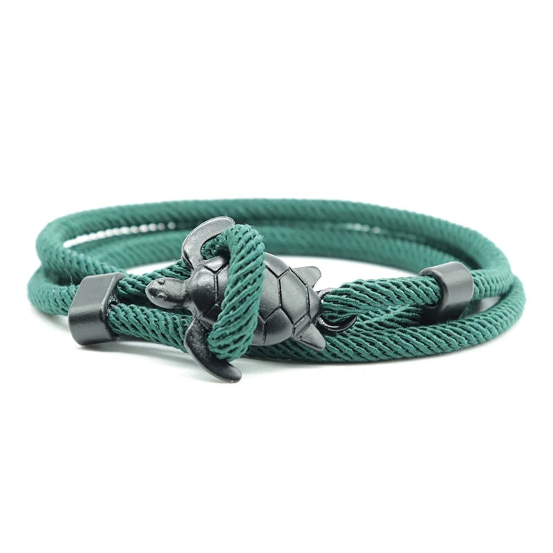 Sea turtle charm close-up on a dark green rope bracelet