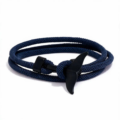 Whale tail charm in black finish on a dark blue rope bracelet