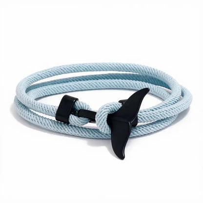 Whale tail charm in black finish on a light blue rope bracelet