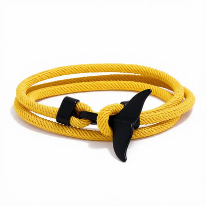 Whale tail charm in black finish on a yellow rope bracelet