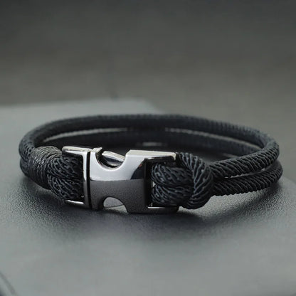 Black double-strand rope bracelet with a gunmetal spring-loaded buckle clasp