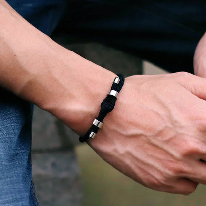 Black adjustable cord bracelet worn on the wrist